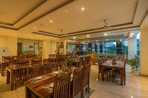 un restaurant avec des tables et des chaises en bois dans l'établissement Moustache Rishikesh Luxuria, à Rishikesh