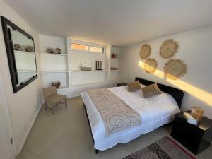 um quarto com uma cama e uma cadeira em Villa à 2 pas de la plage - 4 chambres em Imsouane