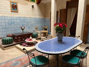 a patio with a table and chairs and a fireplace at Riad Dar Les Freres in Marrakech