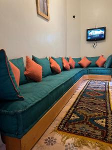 a green couch with orange pillows in a living room at Riad Dar Les Freres in Marrakech
