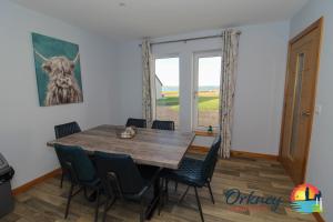 uma sala de jantar com uma mesa e cadeiras e uma janela em Burrian - OR00247F, Lyermira - OR00249F, & Kirkquoy - OR00248F, Harray, Orkney em Orkney