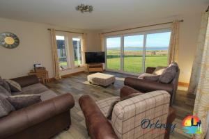 a living room with couches and a flat screen tv at Burrian - OR00247F, Lyermira - OR00249F, & Kirkquoy - OR00248F, Harray, Orkney in Orkney