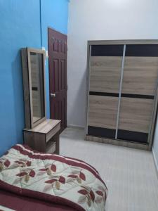 a bedroom with a bed and a mirror and a door at D'illahs Homestay in Alor Setar