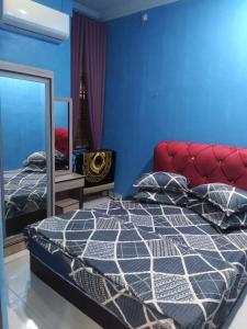 a bedroom with a bed and a mirror at D'illahs Homestay in Alor Setar