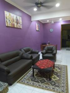 a living room with two couches and a purple wall at D'illahs Homestay in Alor Setar
