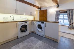 a kitchen with a washing machine and a sink at Brambles Farm in Leek