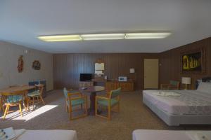 Habitación de hotel con cama, mesa y sillas en Love Hotels Tomahawk at Lake Mohawksin WI, en Tomahawk