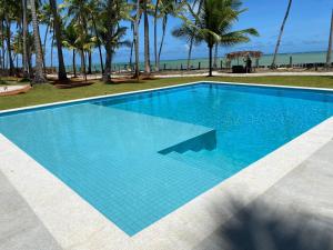 una gran piscina azul junto a una playa en Fazenda Xaréu, en Maragogi