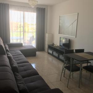 a living room with a couch and a table at Cosy 2 bedroom apartment in Paphos City