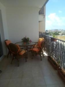 a patio with a table and chairs on a balcony at Cosy 2 bedroom apartment in Paphos +2 photos