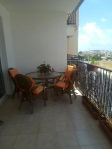 a patio with a table and chairs on a balcony at Cosy 2 bedroom apartment in Paphos City