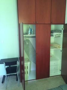 a closet with wooden cabinets and a chair in a room at Cosy 2 bedroom apartment in Paphos