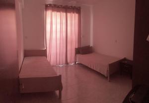 a room with two beds and a window with pink curtains at Cosy 2 bedroom apartment in Paphos