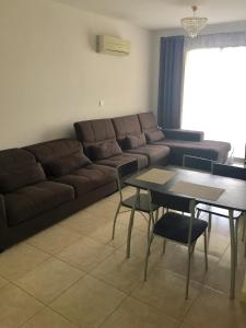 a living room with a couch and a table at Cosy 2 bedroom apartment in Paphos City