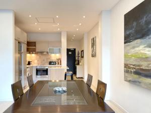 a dining room with a table and a kitchen at Mandela Place Apartment in Cape Town