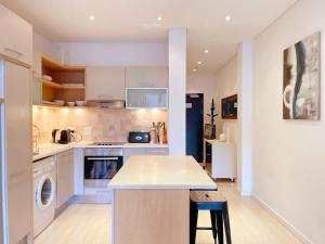 a kitchen with white cabinets and a counter top at Mandela Place Apartment in Cape Town