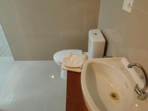 ein Badezimmer mit einem Waschbecken, einem WC und einer Badewanne in der Unterkunft Bale Bali Cottage 2 in Ubud