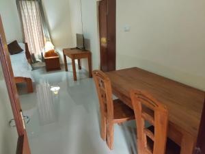 einem Esstisch mit 2 Stühlen und einem TV in der Unterkunft Bale Bali Cottage 2 in Ubud