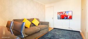 ein Wohnzimmer mit einem braunen Sofa und gelben Kissen in der Unterkunft Bluebell 3 at Regent's Park in London