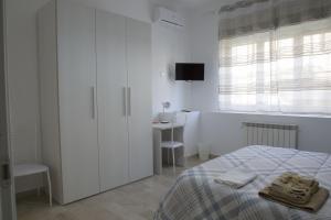 ein weißes Schlafzimmer mit einem Bett und einem Schreibtisch in der Unterkunft A Quattro Passi in San Cataldo