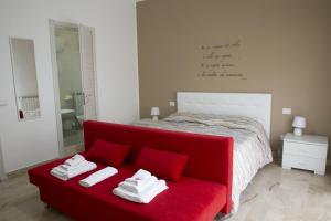 ein Schlafzimmer mit einem roten Sofa und einem Bett in der Unterkunft A Quattro Passi in San Cataldo