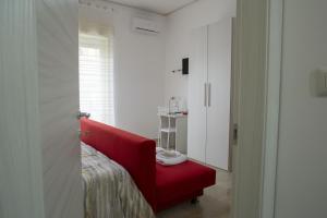 聖卡塔爾多的住宿－A Quattro Passi，白色房间的一个红色椅子,有门
