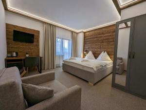um quarto de hotel com uma cama e um sofá em Penzion Maria em Liptovský Mikuláš