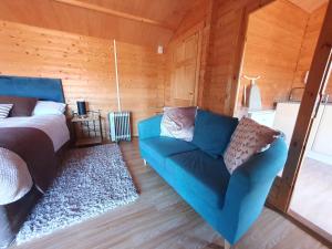 a bedroom with a bed and a blue couch at The Cabin @Tenacre in Boston