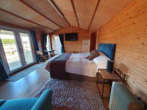 ein Schlafzimmer mit einem großen Bett in einem Holzzimmer in der Unterkunft The Cabin @Tenacre in Boston