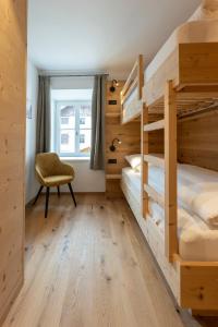 1 dormitorio con 2 literas y 1 silla en Residence Kugler, en San Candido