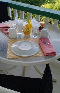 a white plate on a table with a napkin at Little Palace BNB in Saint Georgeʼs