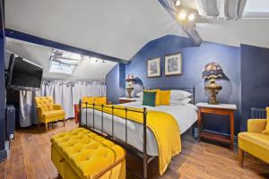 a blue and yellow bedroom with a bed and a tv at The Fat Badger York in York