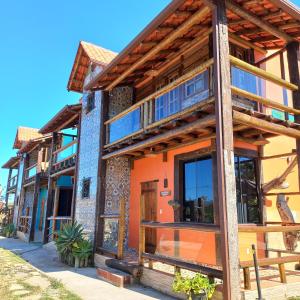 a house with wooden beams and orange at Pousada Cachoeiras do Cipó in Serra do Cipo