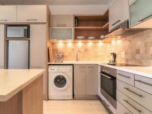 a kitchen with a washing machine and a sink at Mandela Place Apartment in Cape Town