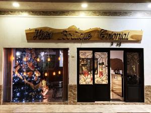 una tienda frente con un árbol de Navidad en la ventana en Hotel Boutique Colonial Cartago, en Cartago