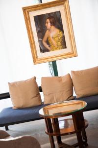 a living room with a couch and a picture of a woman at Cosmo Hotel Torri in Vimercate