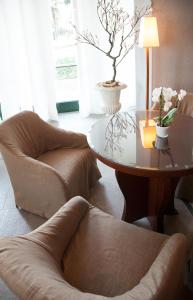 a living room with a table and two chairs and a coffee table at Cosmo Hotel Torri in Vimercate