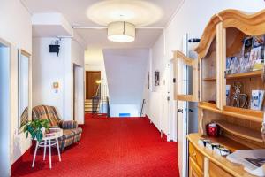 un couloir avec un tapis rouge et un salon dans l'établissement Haus Excelsior Top 3, à Seefeld in Tirol