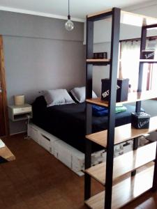 1 dormitorio con cama y estante para libros en Un Hogar en La Feliz en Mar del Plata