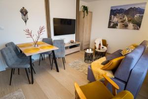 a living room with a blue couch and a table at Apart-Center Przy Krupówkach in Zakopane
