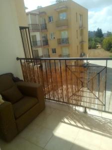 a balcony with a couch and a view of a building at Cosy 2 bedroom apartment in Paphos