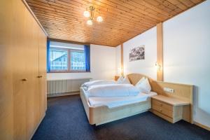 索爾達的住宿－Haus Lena，一间卧室设有一张床和木制天花板