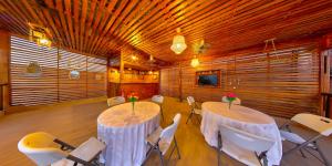 OyibiにあるMaya Villaのテーブル2台と白い椅子が備わる部屋