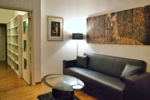 a living room with a couch and a glass table at Arezzo Charming Apartment in Arezzo