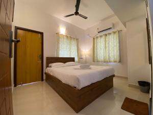 a bedroom with a large bed and a ceiling fan at Le Poshe Luxury in Puducherry