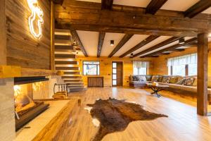 a living room with a fireplace in a log house at Moșia Sofiei in Moieciu de Sus