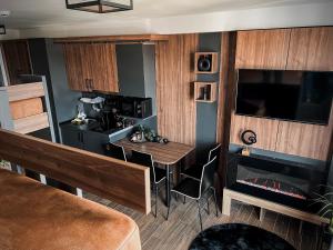 a living room with a table and a fireplace at MIR i LIRA apartmani Kopaonik in Kopaonik