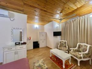 a living room with two chairs and a tv at Bougainvillea Retreat & Spa in Kāhārpāra