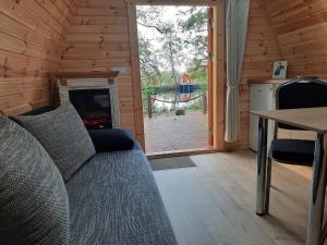 a living room with a couch and a fireplace at 28 Premium Camping Pod in Silberstedt