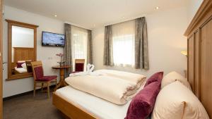 a hotel room with two beds and a mirror at Jungmann Apartments in Ischgl